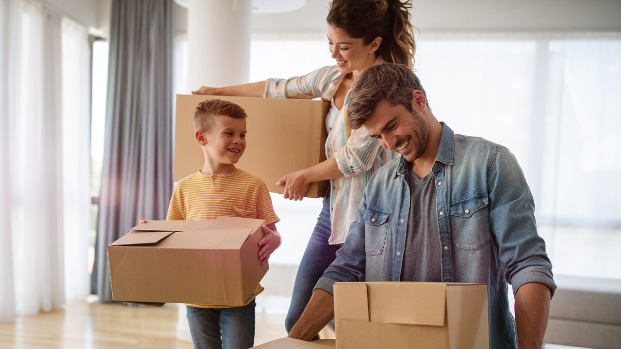 Jeune famille transportant des cartons de déménagement